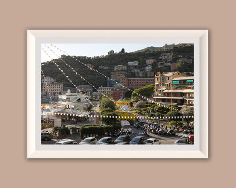 Fine art photograph of Recco's waterfront decorated with festival banners as afternoon light falls across the Italian Riviera.