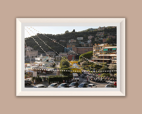 Fine art photograph of Recco's waterfront decorated with festival banners as afternoon light falls across the Italian Riviera.