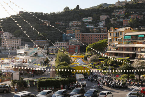 Fine art photograph of Recco's waterfront decorated with festival banners as afternoon light falls across the Italian Riviera.