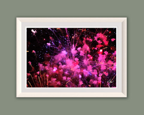 Abstract fine art photograph capturing an explosion of pink and purple fireworks illuminating the night sky.