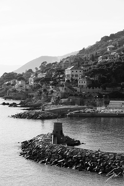 Fine art photography wall print featuring a monochrome view of the Ligurian coastline with its historic breakwater, harbor, and Mediterranean village.