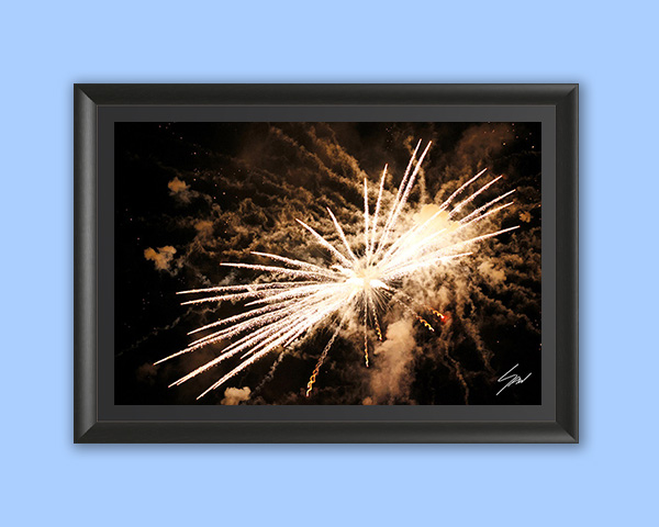 Travel fine art wall print featuring a radiant burst of fireworks illuminating the night with light, movement, and energy.
