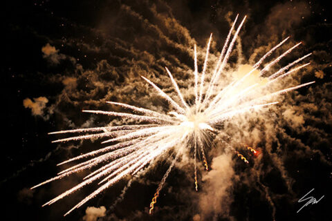 Travel fine art wall print featuring a radiant burst of fireworks illuminating the night with light, movement, and energy.