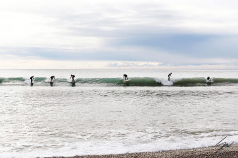Party Wave fine art print captures surfers sharing a wave in Recco, Italy. Coastal photography inspired by surf culture and life on the Ligurian Sea.