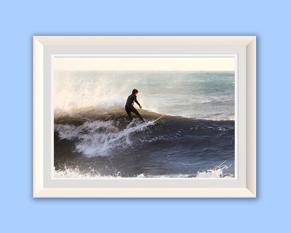 Travel fine art photography wall art featuring a lone surfer riding an ocean wave, bringing movement and energy to any space.