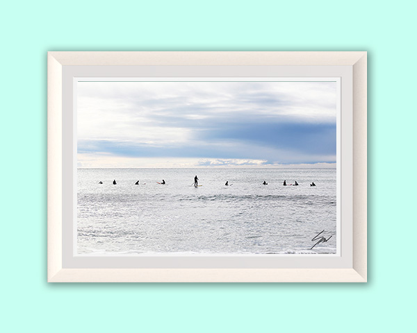 Fine art photography wall print featuring surfers scattered across the Mediterranean, capturing stillness, patience, and the rhythm of the sea.