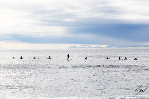 Fine art photography wall print featuring surfers scattered across the Mediterranean, capturing stillness, patience, and the rhythm of the sea.