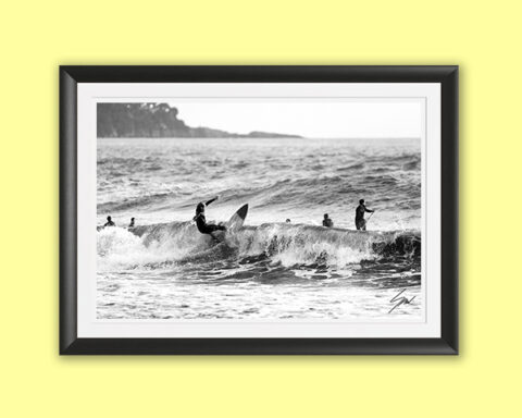 Black and white fine art photograph of a surfer carving across a breaking wave, capturing power, balance, and the timeless rhythm of the sea.