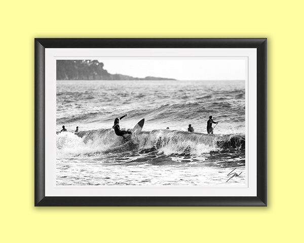 Black and white fine art photograph of a surfer carving across a breaking wave, capturing power, balance, and the timeless rhythm of the sea.