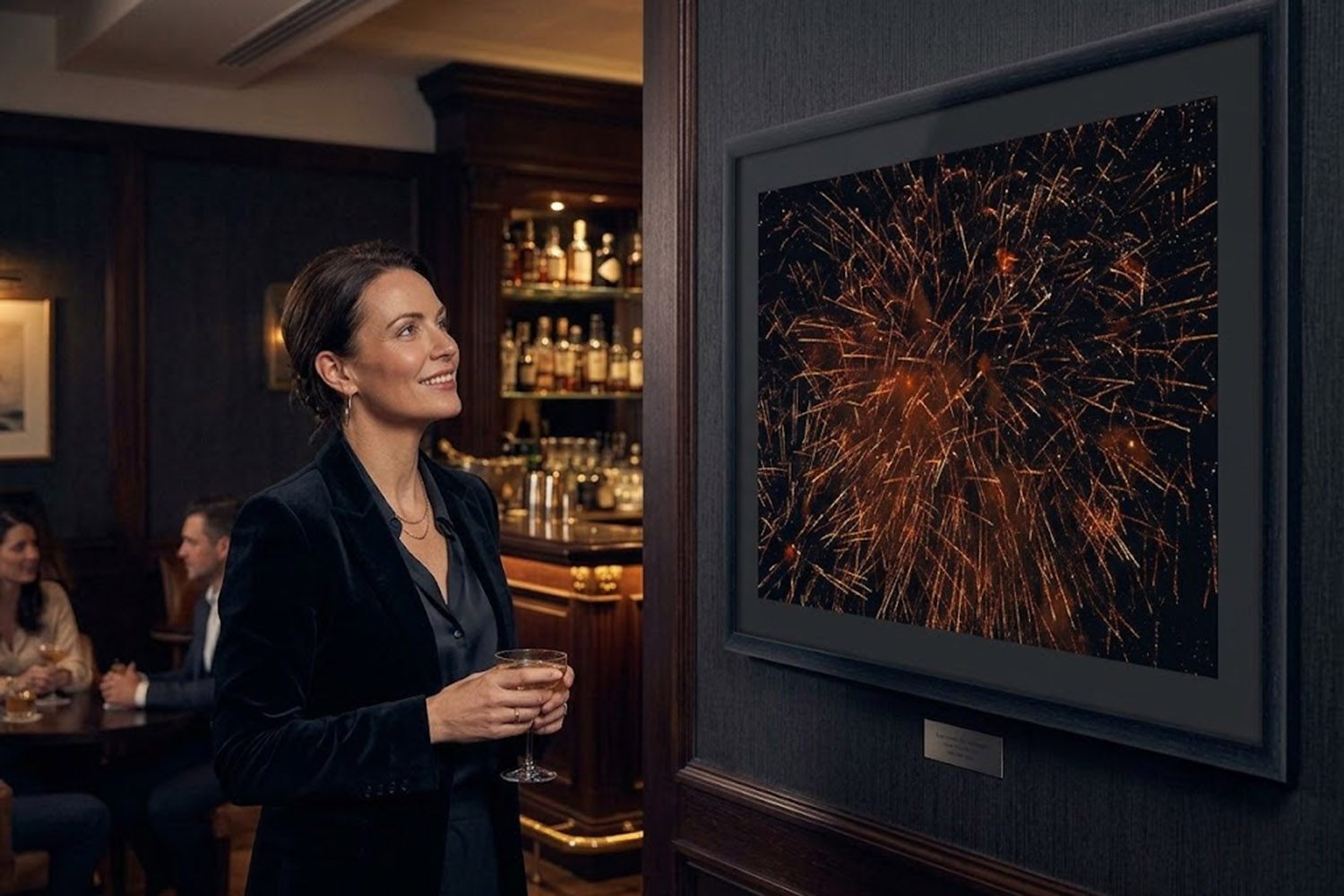Fine art photography print of golden fireworks over Recco, Italy, displayed in a black frame on the wall of an elegant lounge.