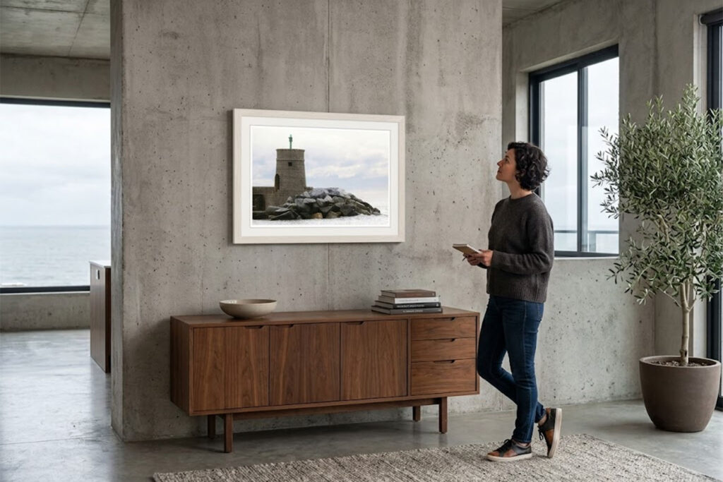Fine art photograph of a historic stone breakwater tower standing against crashing waves and a cloudy Ligurian sky.