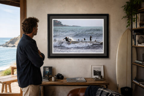 Fine art print, travel photography print capturing a surfer carving across a wave as other surfers wait beyond the break on the Italian Riviera.